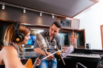Hispanic producer and young singer working in the recording studio